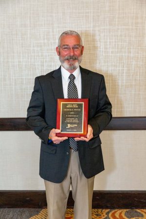 George Pettus holding Lois Britt Service Award